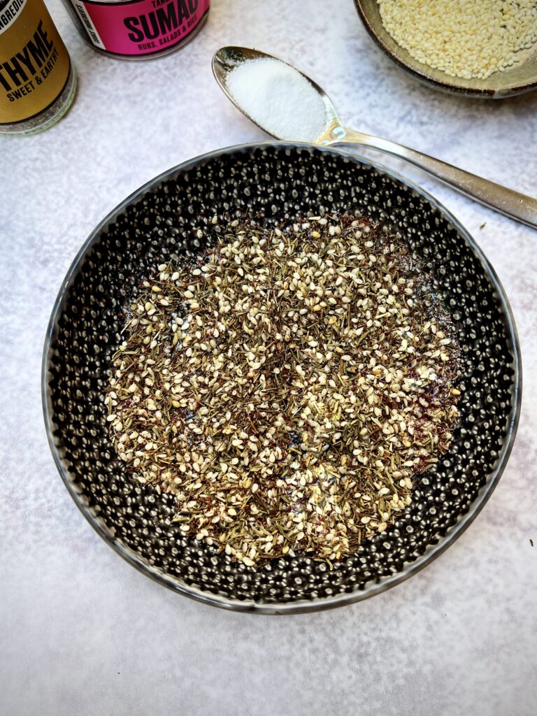 A small black bowl with za'atar - a mix of white sesame seeds, sumac, salt and dried thyme.