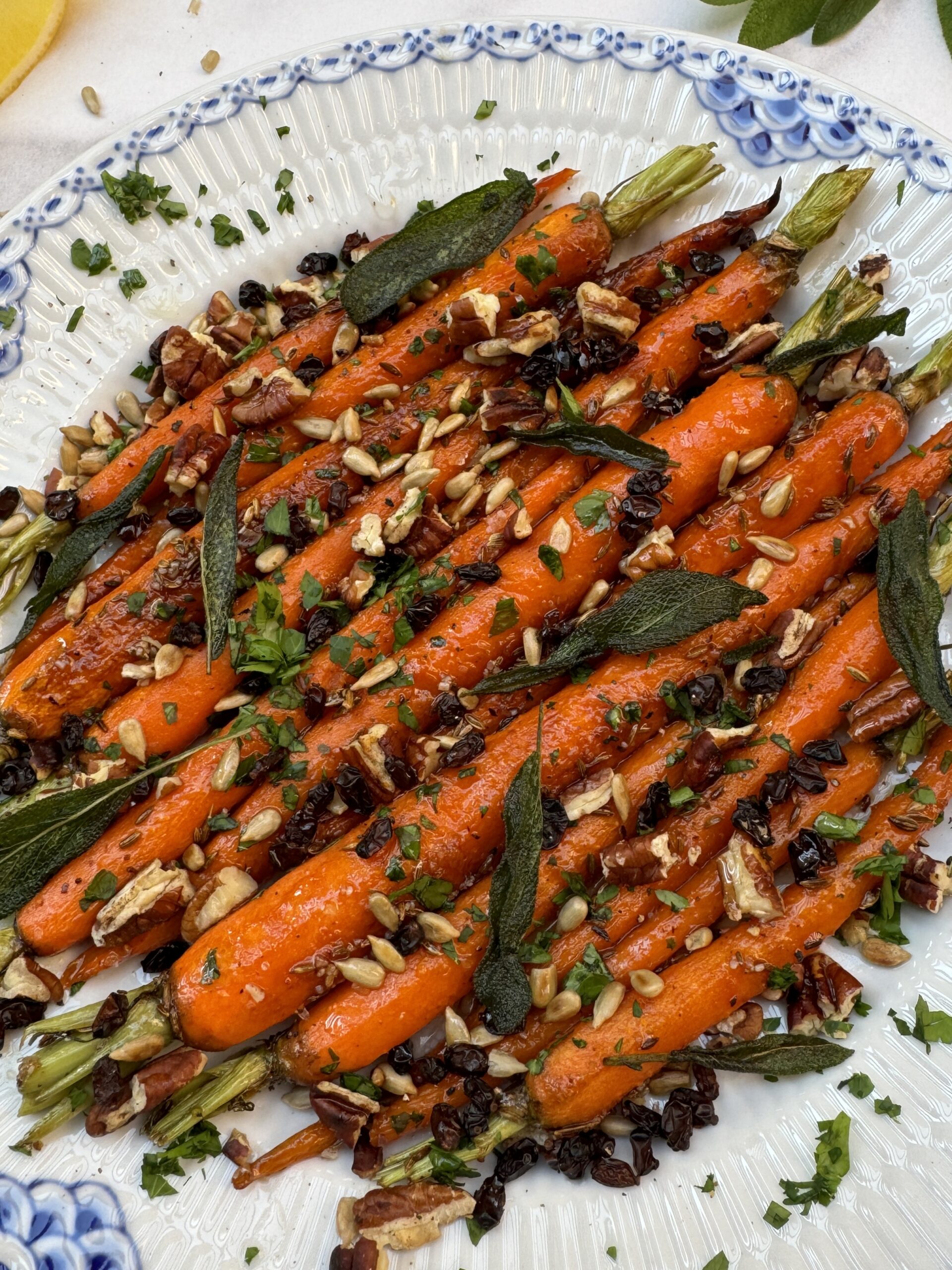 glazed carrots topped with seeds, chopped parsley and crispy sage leaves