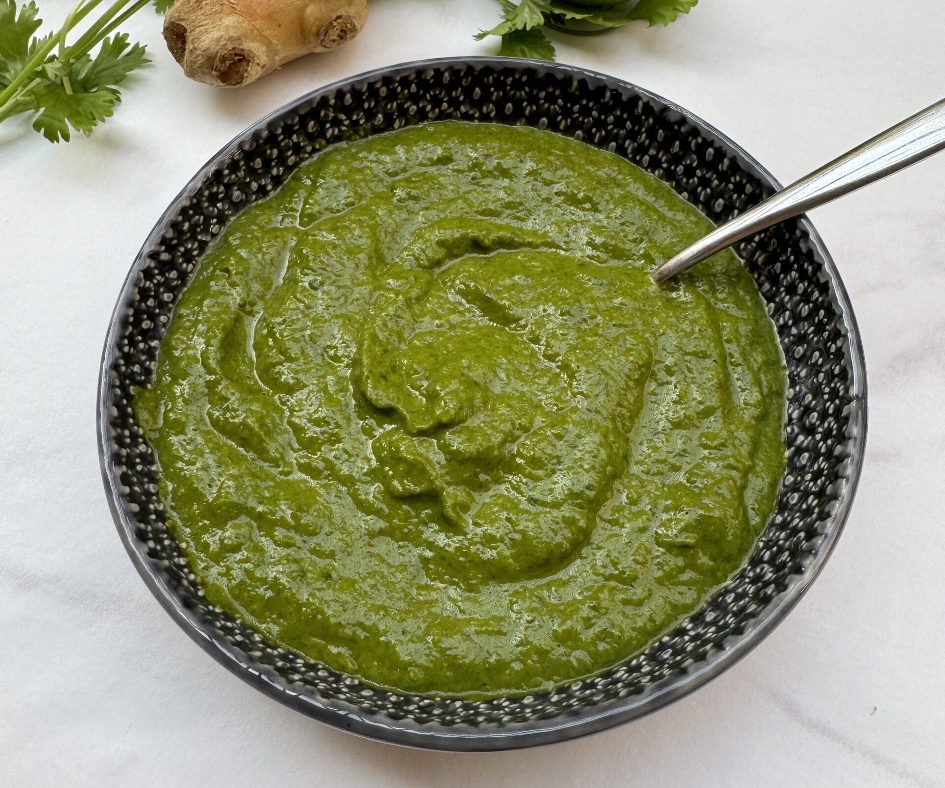 green thick smooth sauce in a dark grey bowl