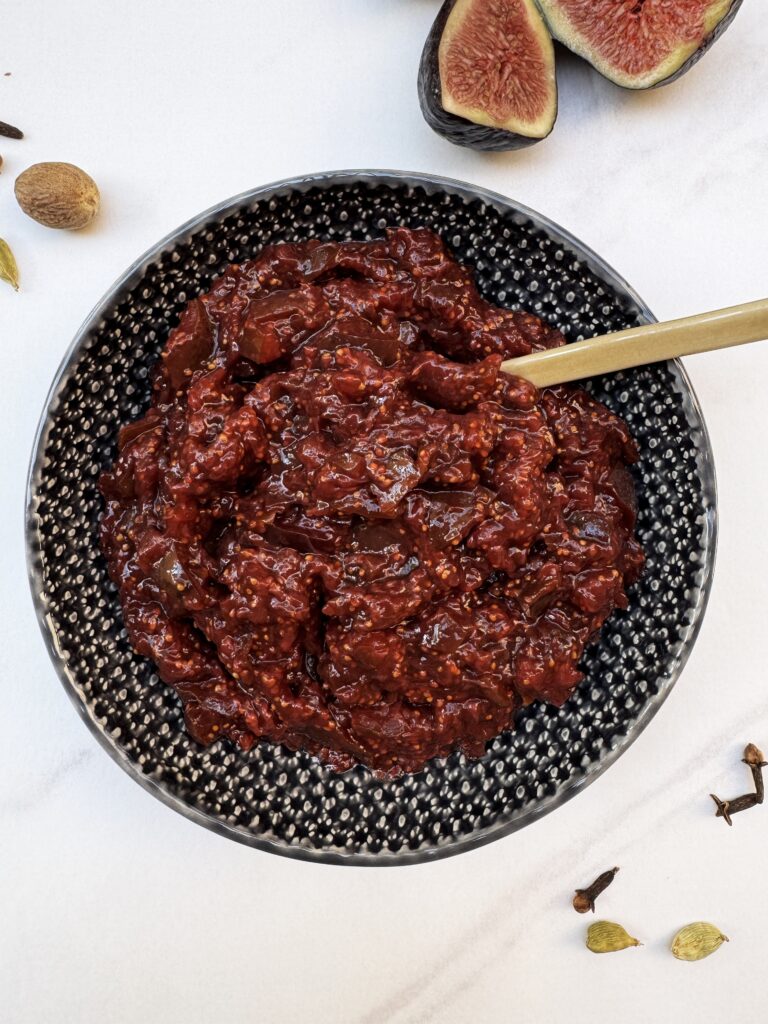 fig chutney in a grey bowl with a little spoon sticking out