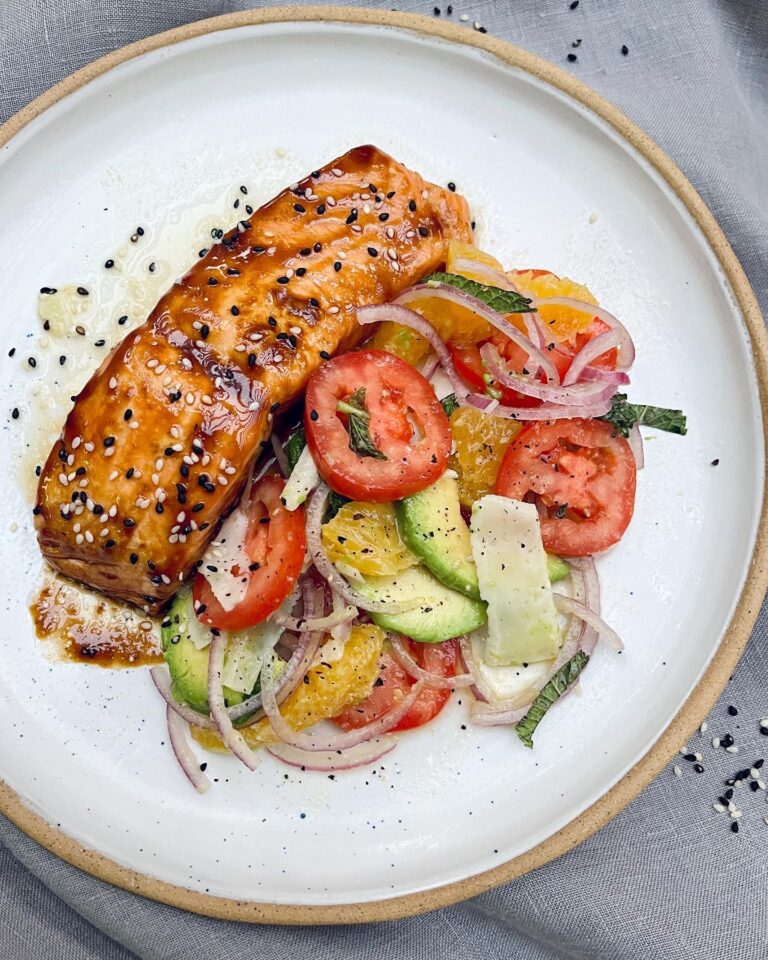 Baked salmon fillet coated with a glossy orange glaze and topped with sesame seeds