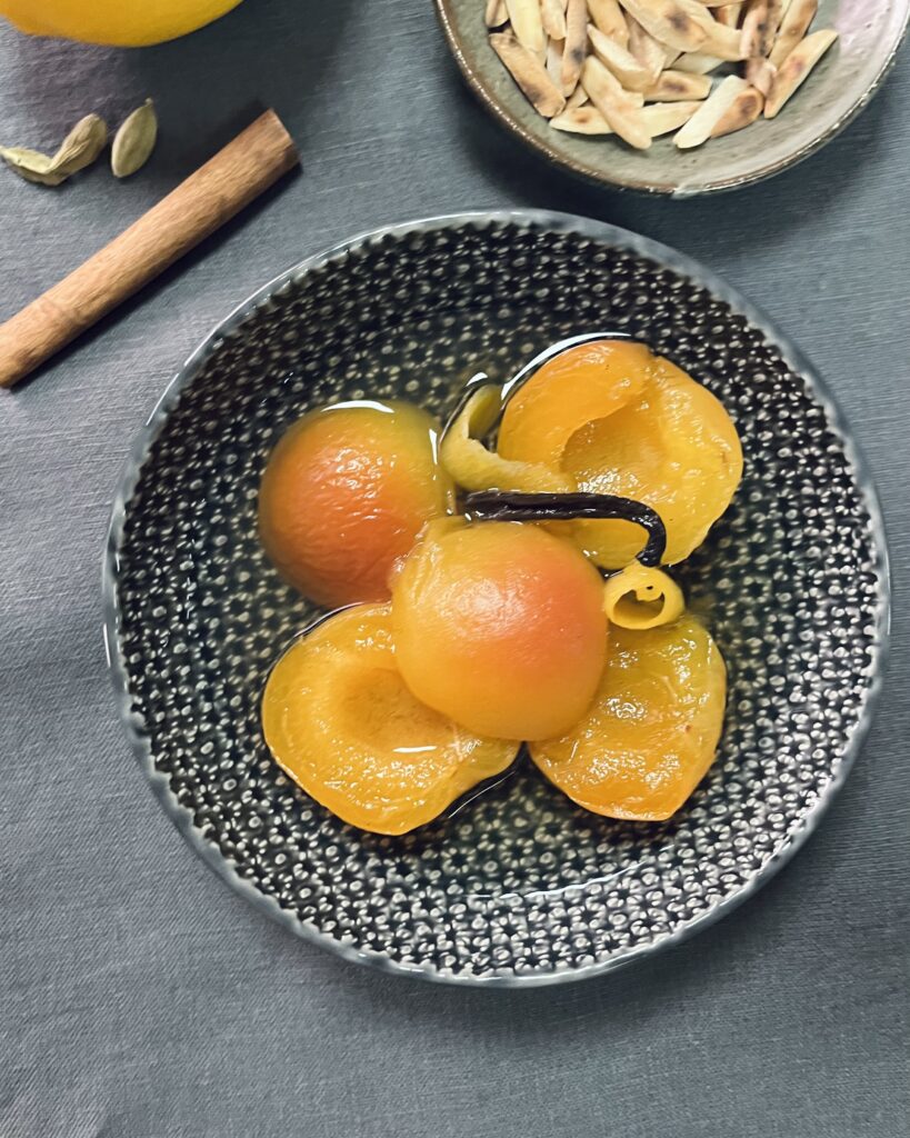 a bowl with poached apricots in a syrup