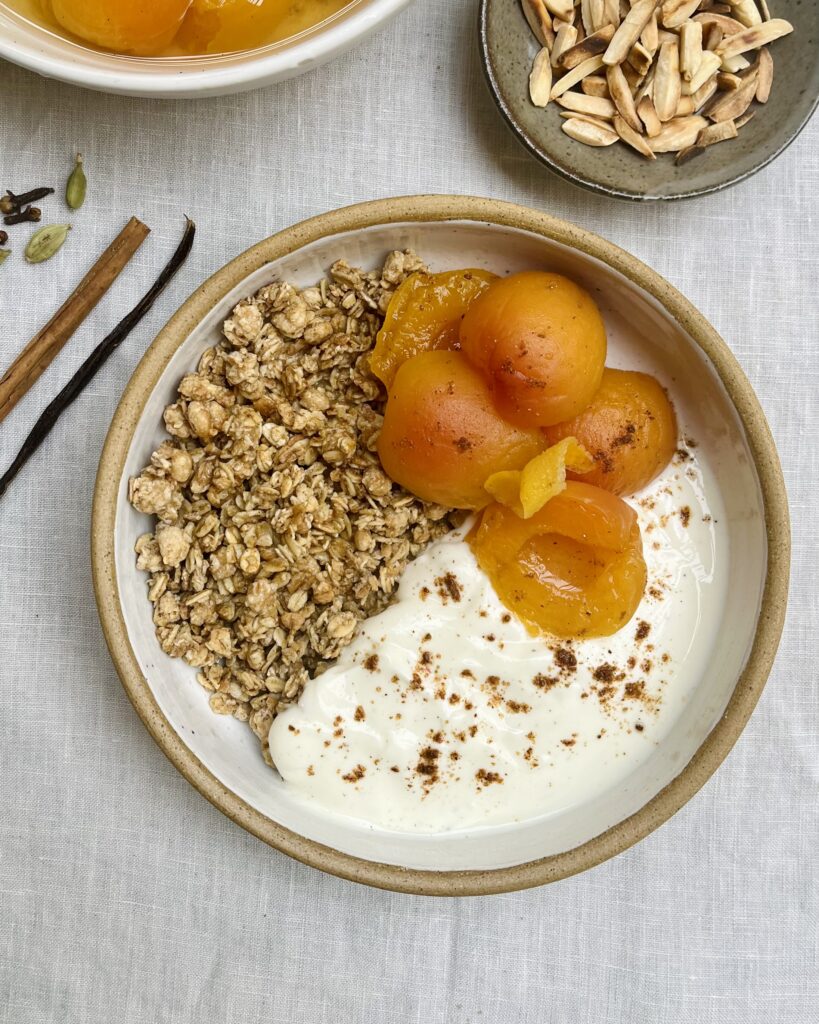 a bowl with poached apricots, yoghurt and granola