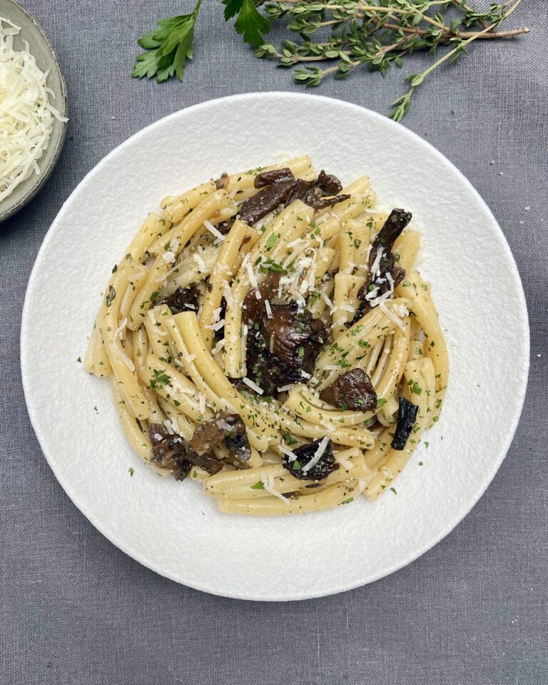 Pasta with wild mushrooms topped with grated parmesan and fresh parsley