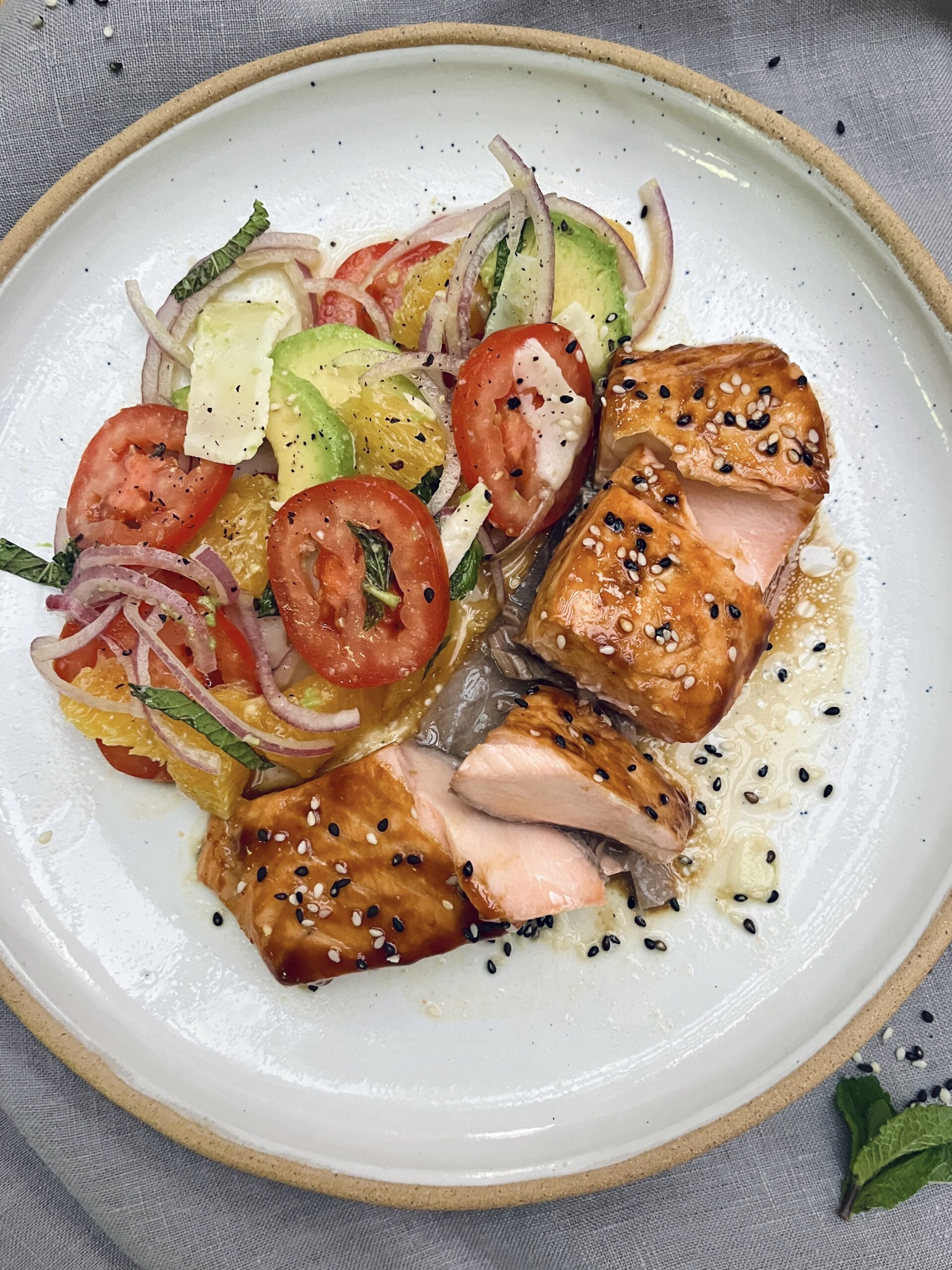 Baked salmon fillet coated with a glossy orange glaze and topped with sesame seeds