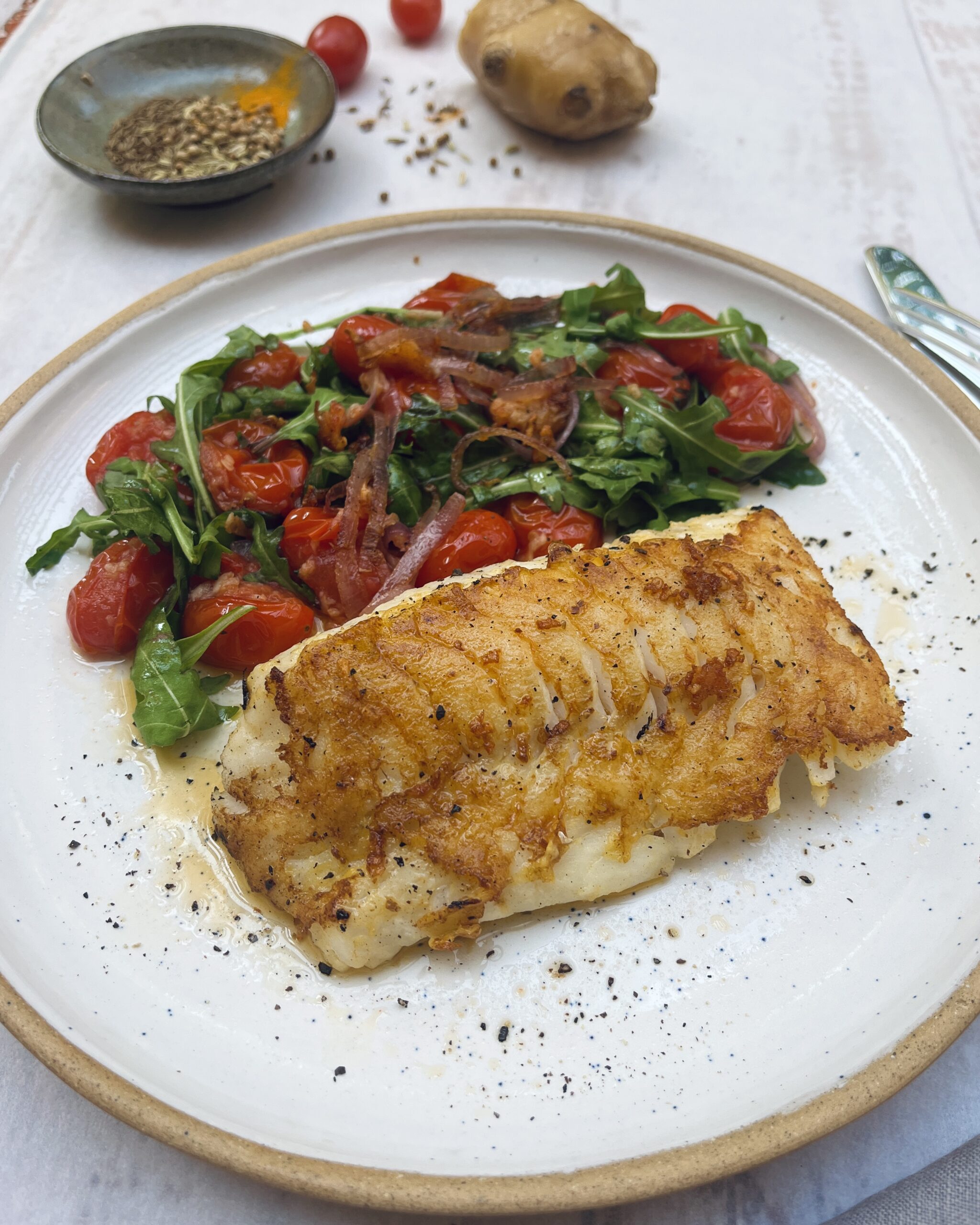 Cod filler in golden batter with tomatoes and ruccola salad