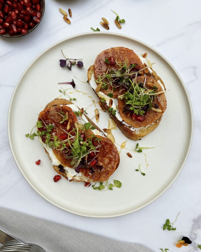 a plate with two grilled sourdough toasts with persimmons and whipped ricotta