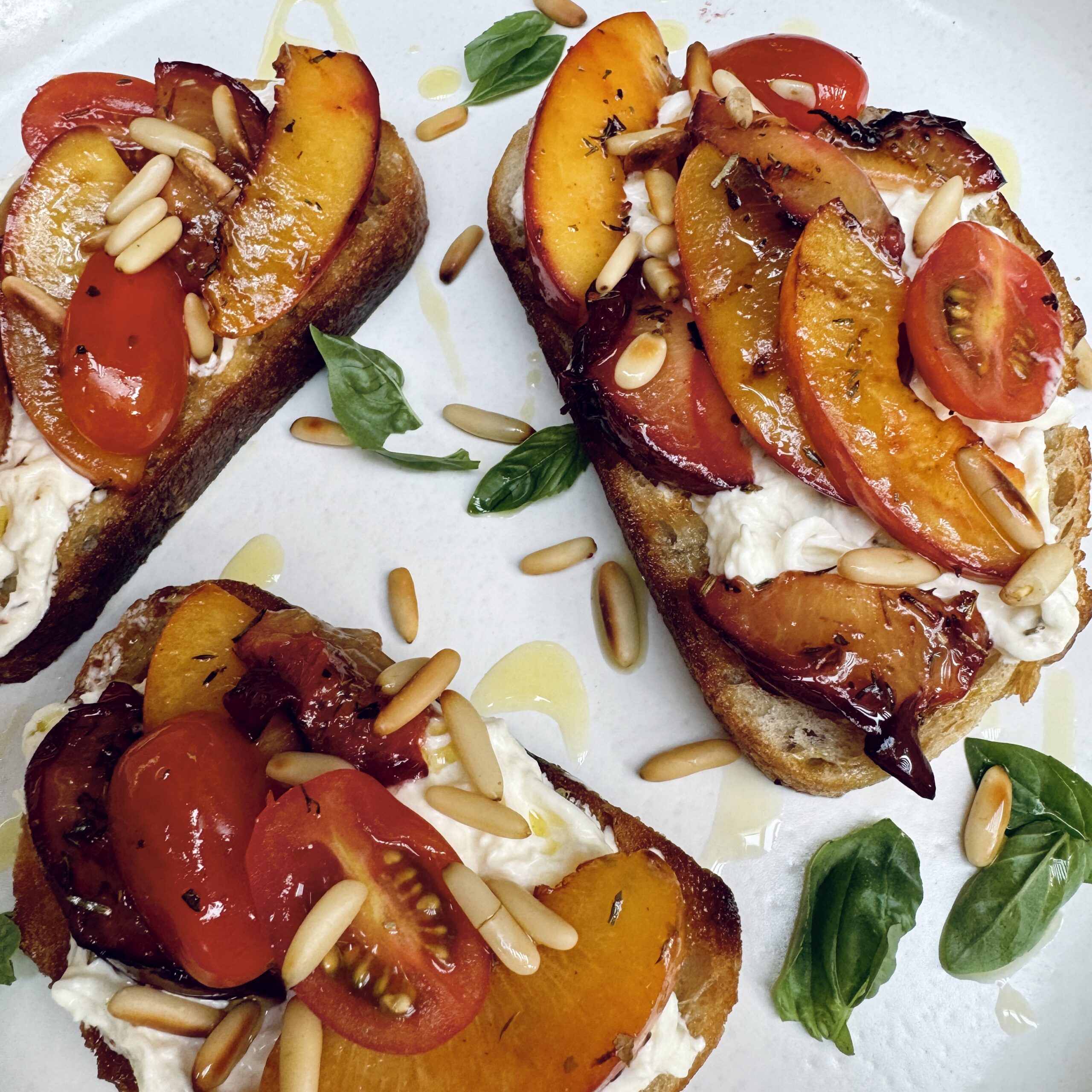 sourdough toast with grilled sliced nectarine, burrata, cherry tomatoes, pine nuts and basil