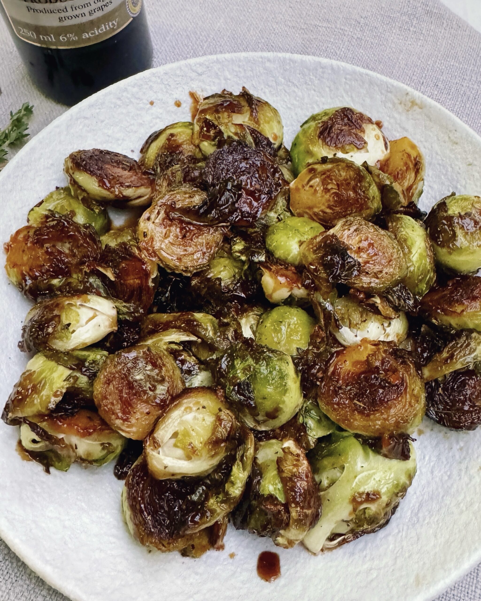 A plate with Brussels sprouts in sticky and glossy orange glaze