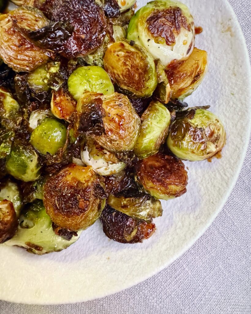 A plate with Brussels sprouts in sticky and glossy orange glaze