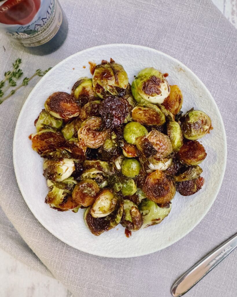 A plate with Brussels sprouts in sticky and glossy orange glaze