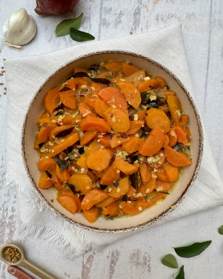 Carrot curry in a rich coconut gravy with aromatics and grated coconut