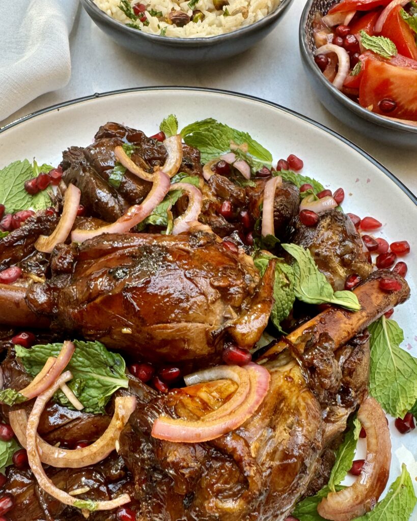 braised lamb shanks coated with a glaze and garnished with marinated onions