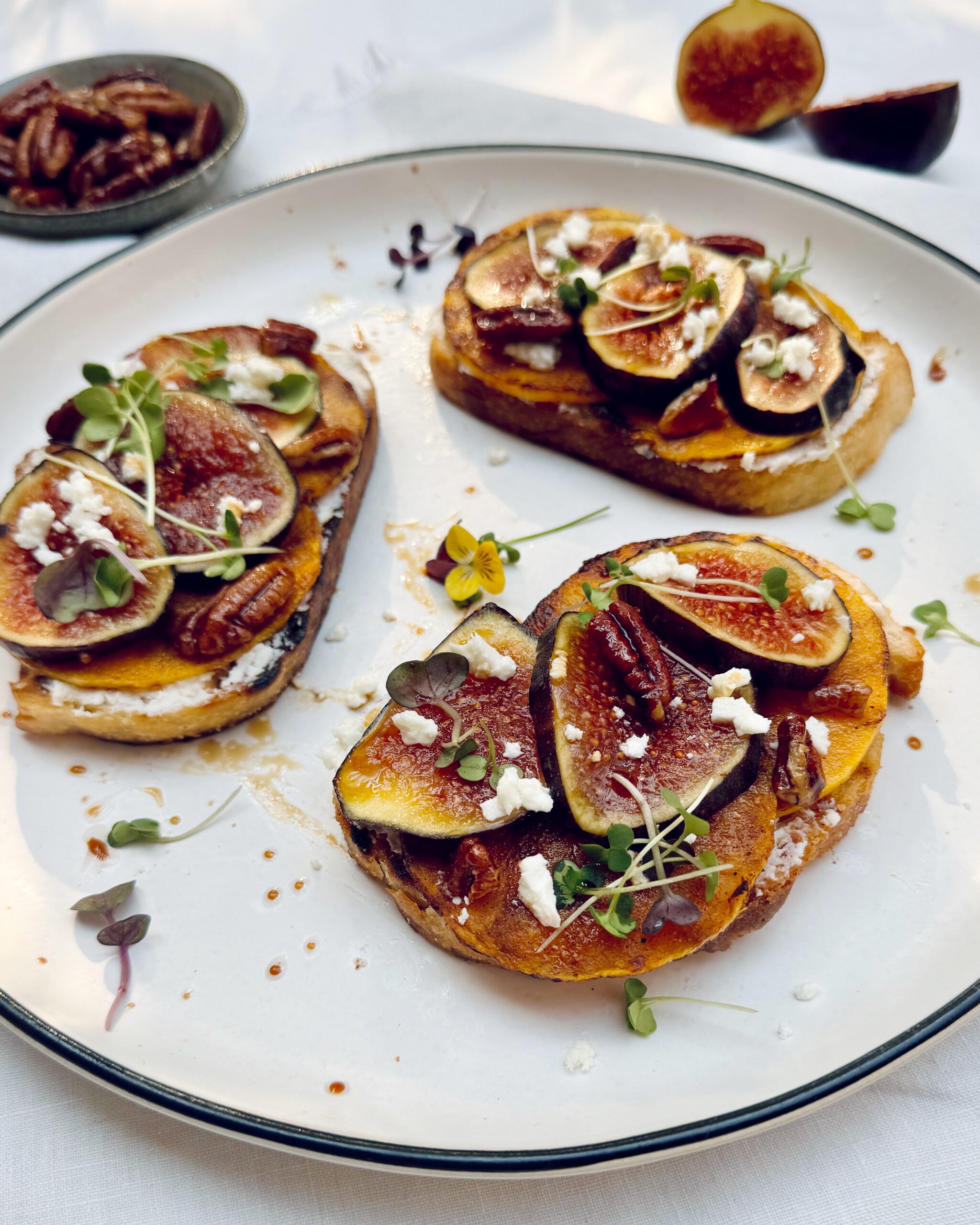 a close up on a plate with grilled sourdough toast with butternut squash, figs and feta