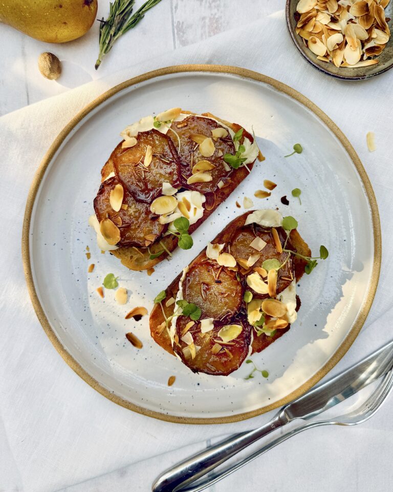 a plate with sourdough toasts with caramelized pears, brie and almonds