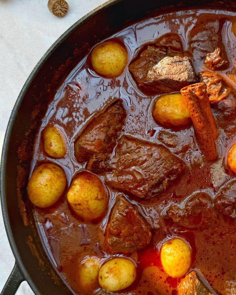 close up on a casserole with beef stew in red sauce with young potatoes