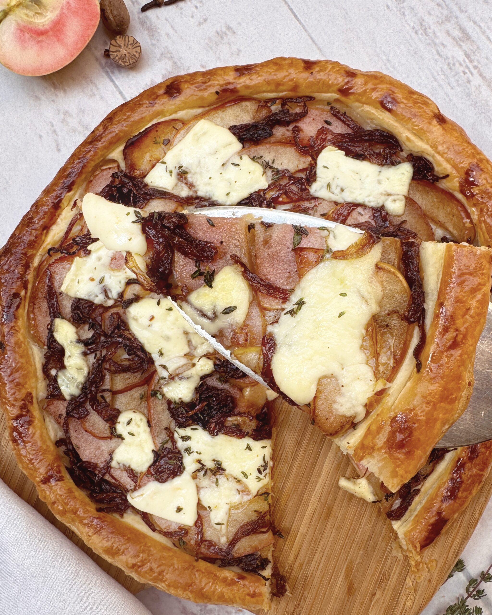 a close up on a slice of Caramelized Apple and Onion Tart with Brie and Thyme