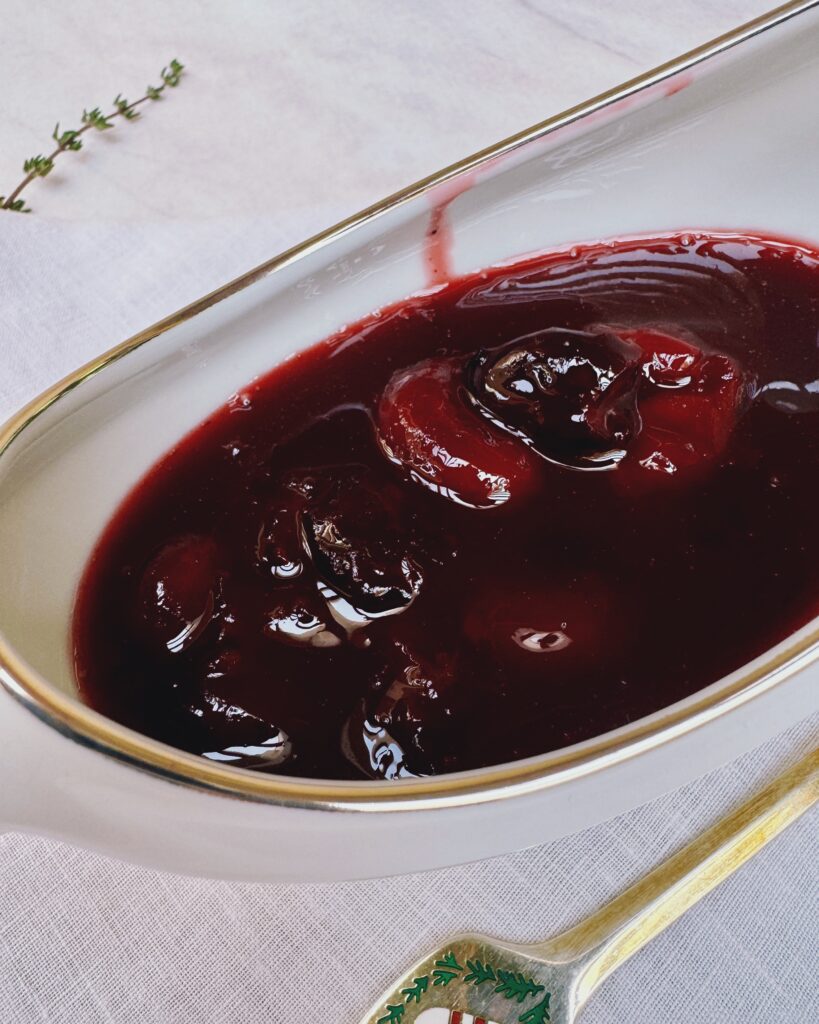 a close up on a sauce jar with berry sauce with cherries and cranberry juice