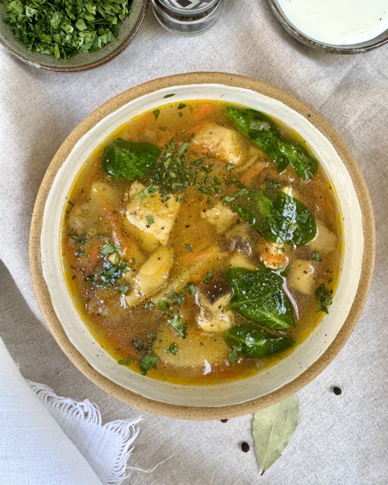 a bowl with Mushroom soup with king bolete, potatoes, spinach, garnished with parsley