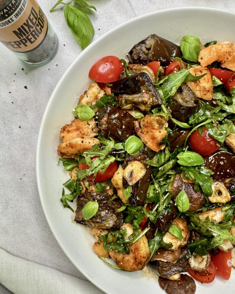 a plate with Prawn Salad with fried eggplant, shiitake mushrooms, garlic chips, tomatoes and greens