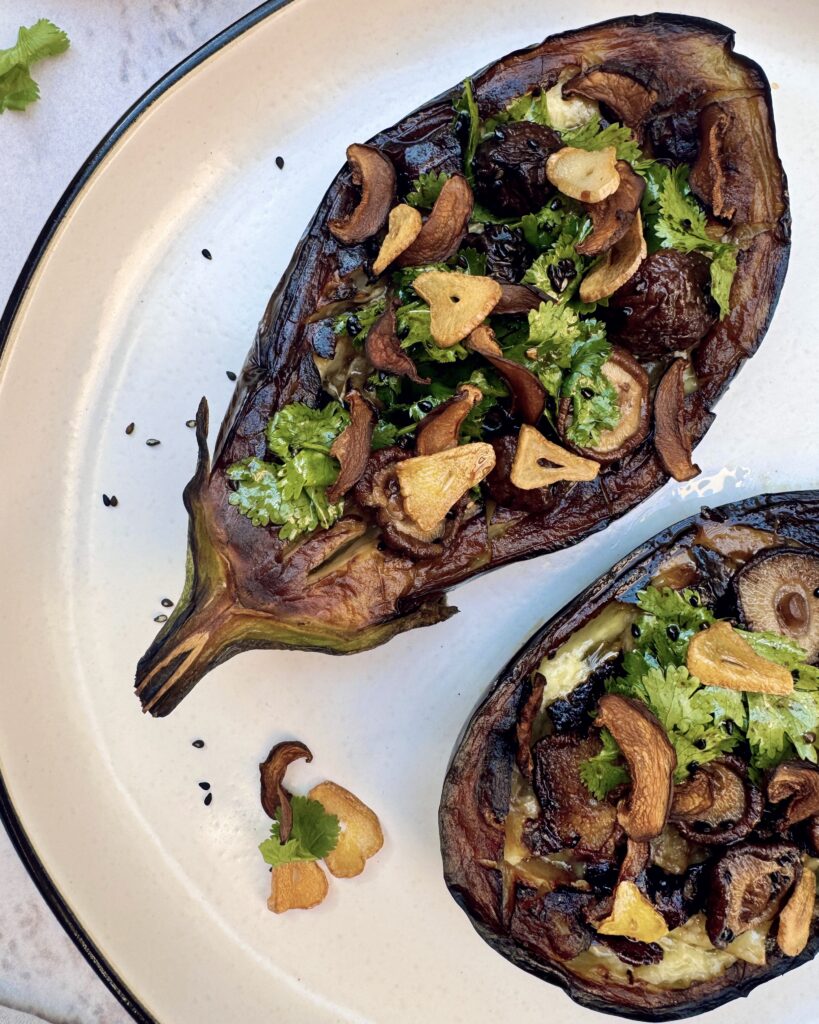 Eggplant halves stuffed with a mixture of garlic chips, shiitake and coriander with sesame truffle dressing
