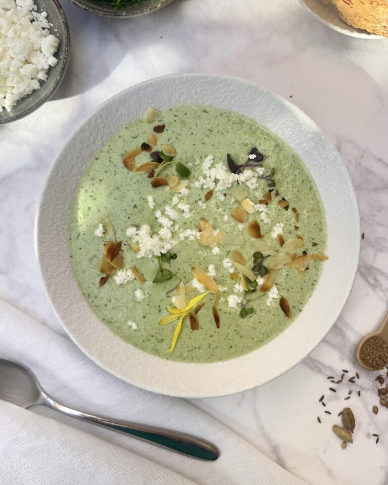 a plate with light green cucumber gazpacho with toppings