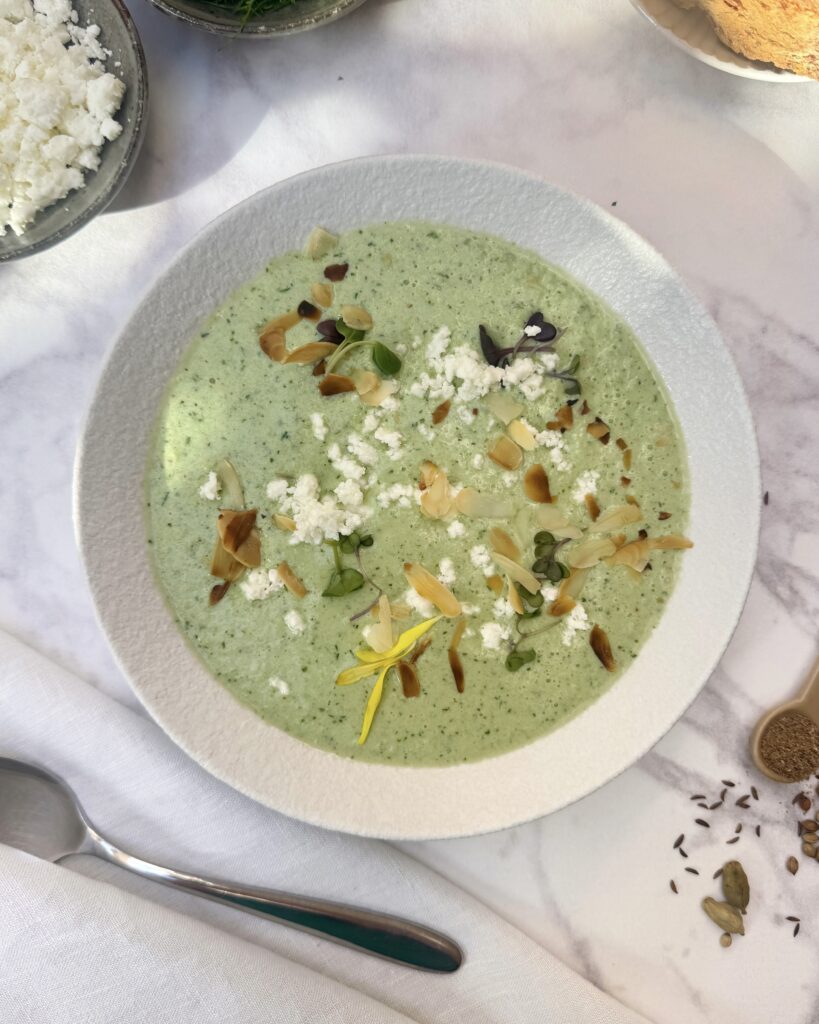 a plate with light green cucumber gazpacho with toppings